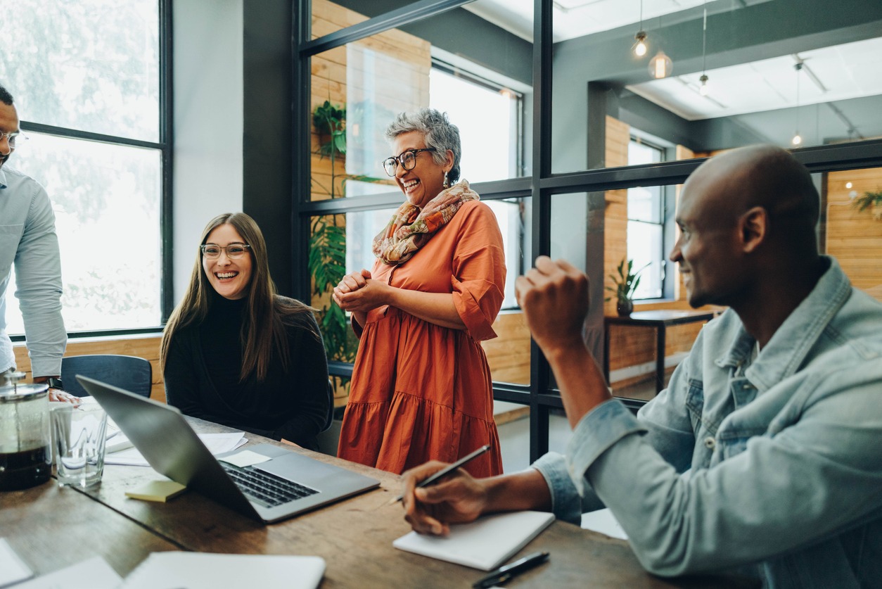 Diverse businesspeople smiling cheerfully during an office meeting People in a meeting in an office, cheerful