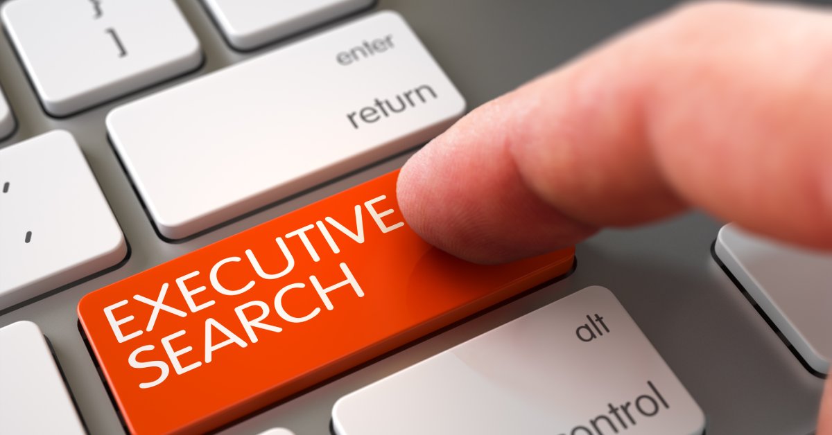 A close-up of a finger pressing a bright red button that reads "executive search" on a laptop keypad.